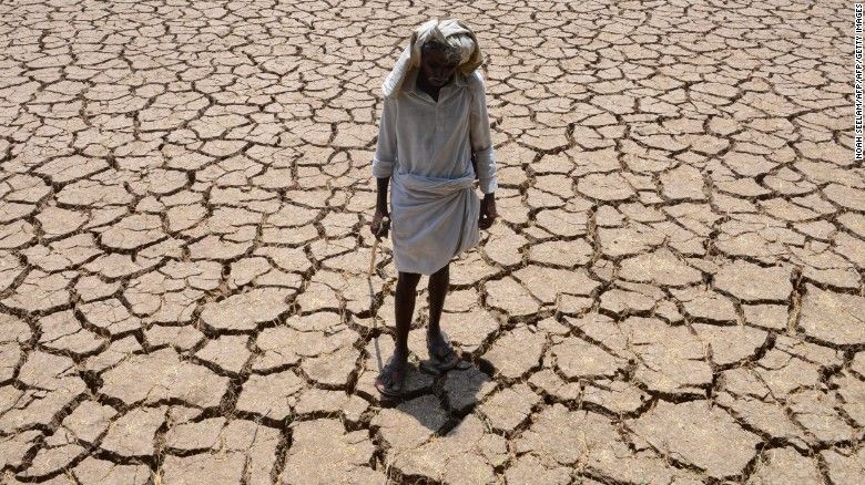 An Indian farmer poses in his dried up cotton field at Chandampet Mandal in Nalgonda east of Hyderabad on April 25, in the southern Indian state of Telangana.