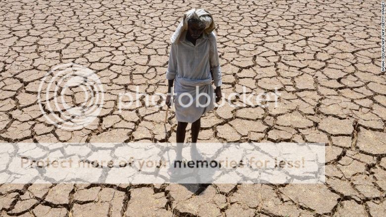 An Indian farmer poses in his dried up cotton field at Chandampet Mandal in Nalgonda east of Hyderabad on April 25, in the southern Indian state of Telangana.